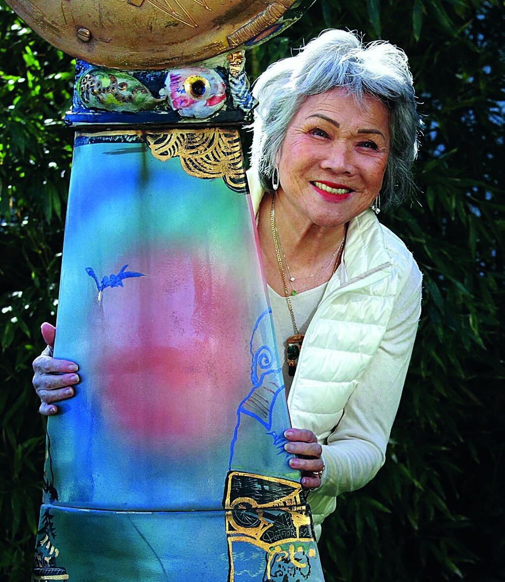 Annette Portanier dans l'Atelier-Galerie, tenant une œuvre de Gilbert