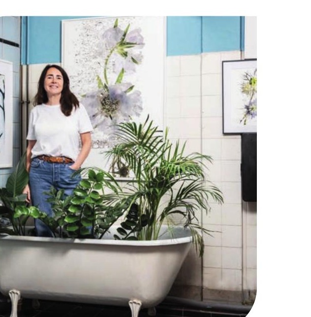 Sophie Le Gendre, autoportrait près de la baignoire entourée de plantes, ses œuvres florales aux murs